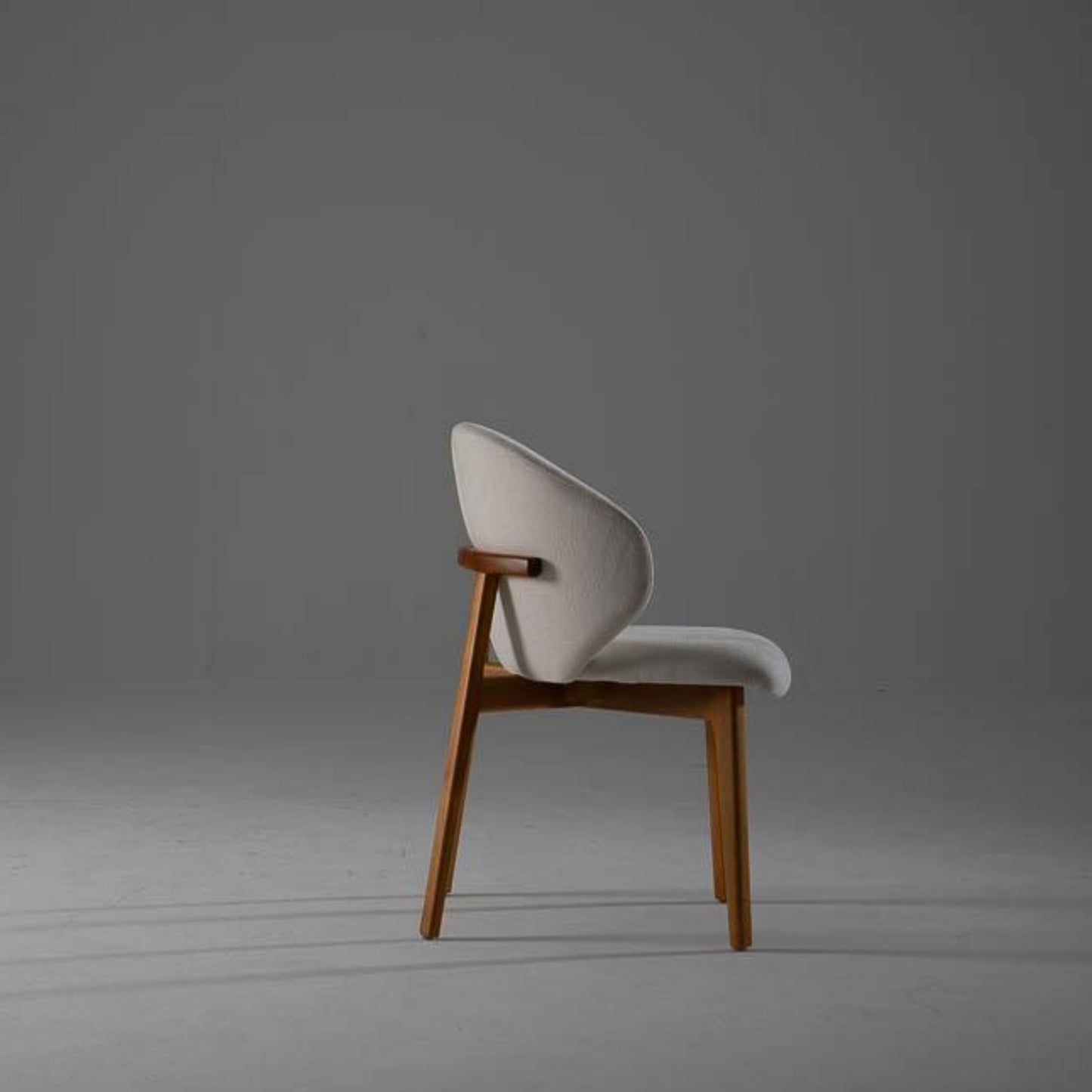 Side profile of the Kayra Dining Chair showcasing slim silhouette and tapered eucalyptus wood legs.